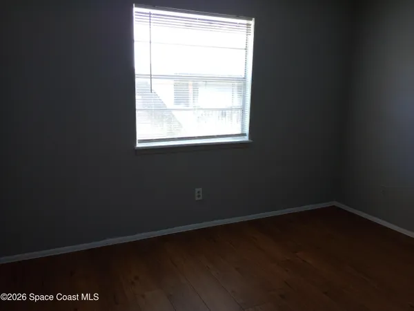 a view of a small space with wooden floor and a window