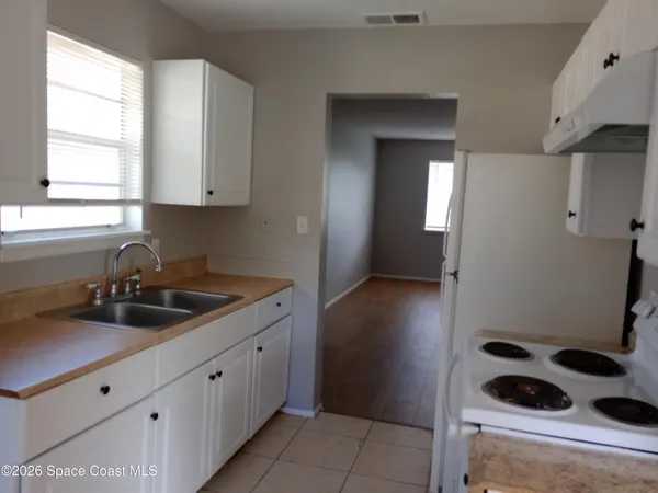 a kitchen with a sink a stove and cabinets