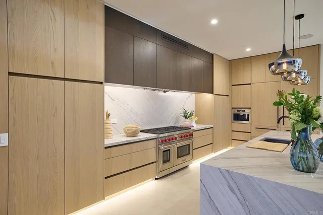 a kitchen with stainless steel appliances kitchen island granite countertop a refrigerator a stove and a sink