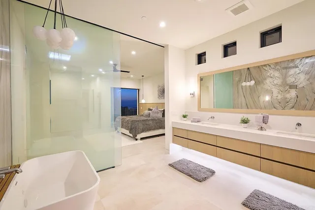 a bathroom with a tub a sink a mirror and a shower