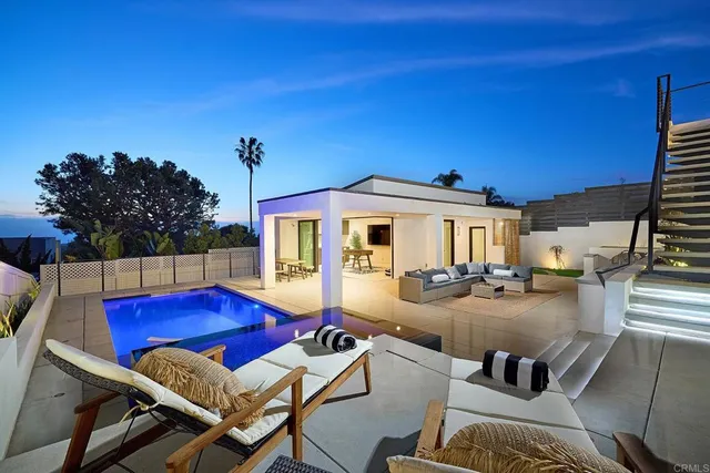 a view of a house with swimming pool and sitting area