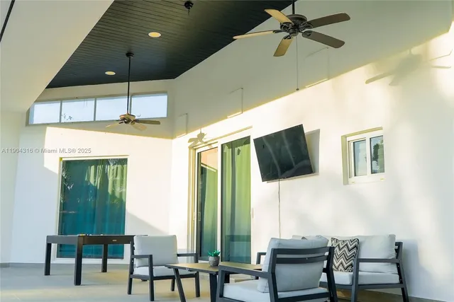 a view of a white house with a big yard and palm trees
