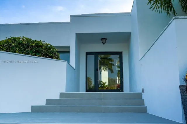 a hallway with stairs and a potted plant
