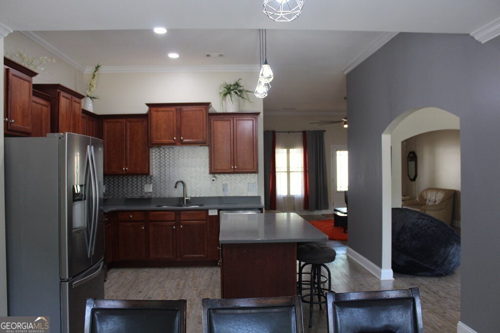 33 Lee Road Phenix City, AL 36870 - Photo 7 of 47 a kitchen with a refrigerator a sink dishwasher a dining table and chairs