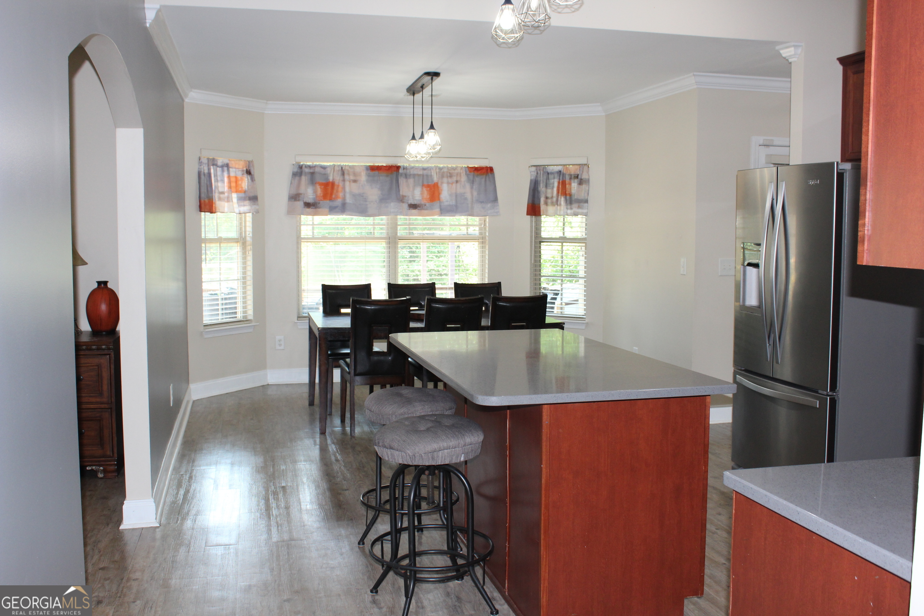 33 Lee Road Phenix City, AL 36870 - Photo 9 of 47 a kitchen with stainless steel appliances granite countertop a refrigerator a stove a dining table and chairs with wooden floor