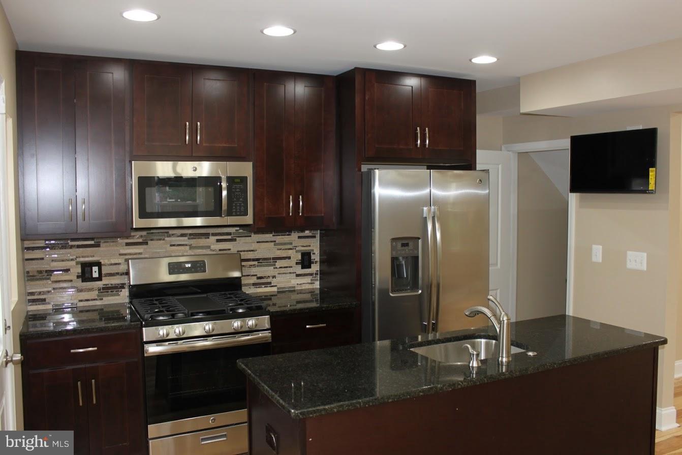1000 Witherspoon Road Baltimore, MD 21212 - Photo 3 of 21 a kitchen with stainless steel appliances granite countertop a refrigerator and a stove