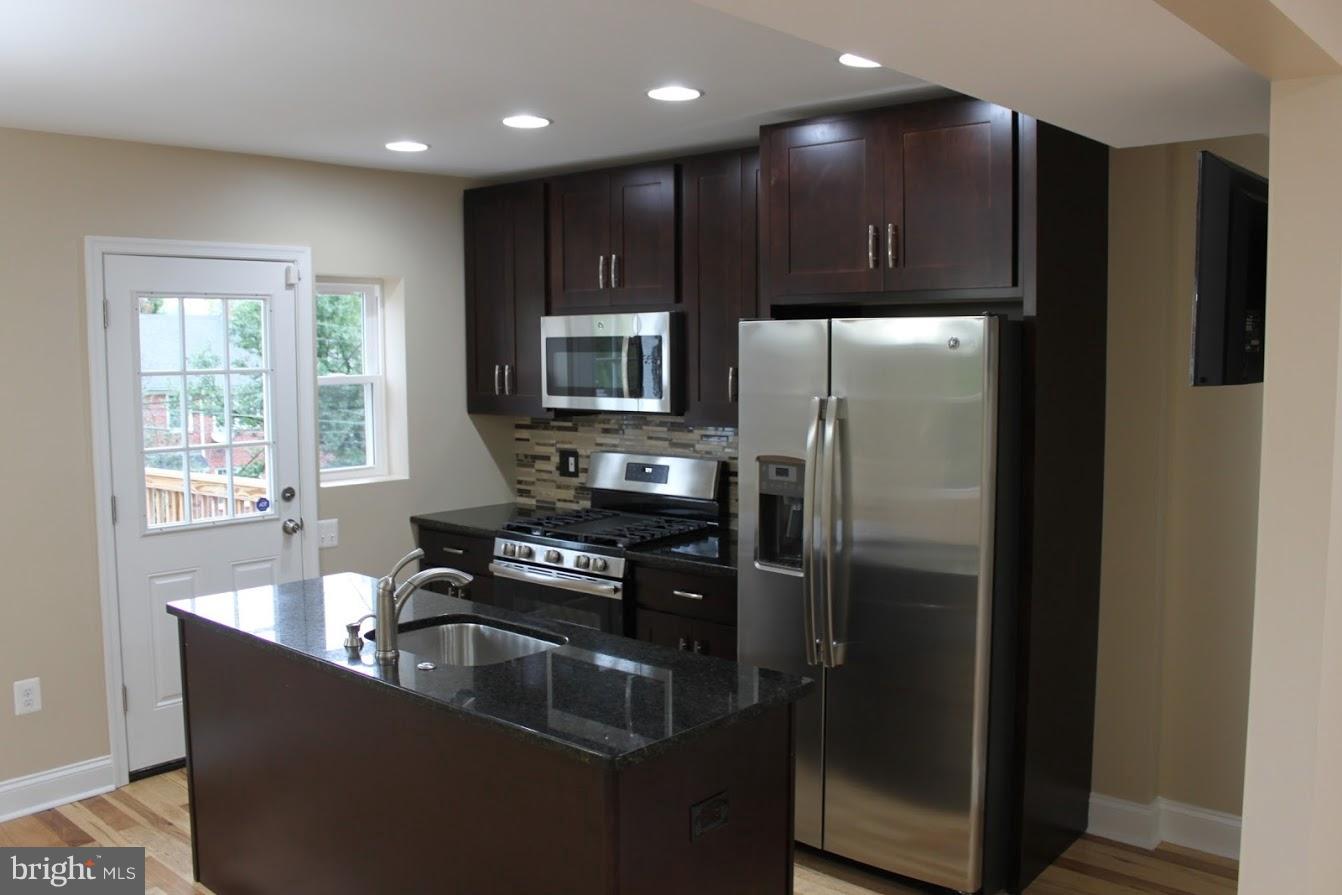 1000 Witherspoon Road Baltimore, MD 21212 - Photo 8 of 21 a kitchen with kitchen island granite countertop stainless steel appliances cabinets a sink and a window