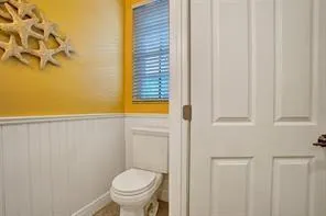 a bathroom with a toilet and a shower curtain