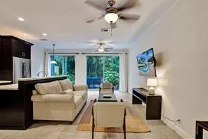 a living room with furniture a large window and a chandelier