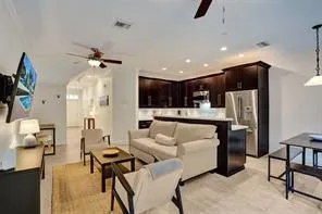 a living room with furniture and a kitchen view