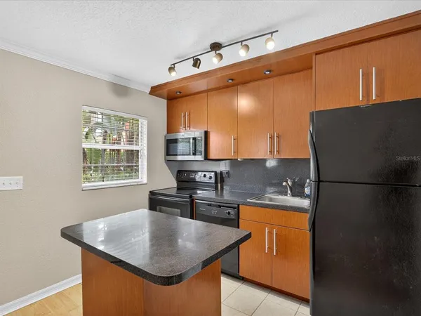 a kitchen with stainless steel appliances granite countertop a sink and a refrigerator