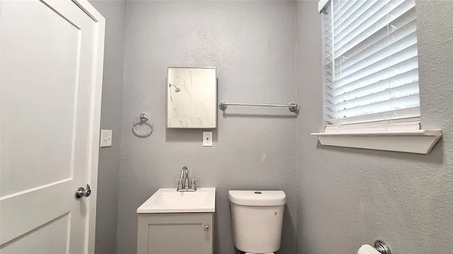 a bathroom with a toilet sink and mirror