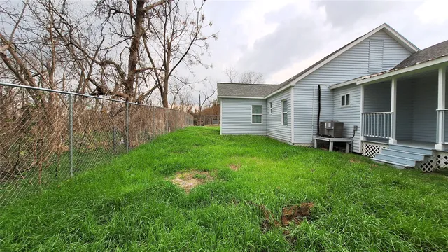 a view of a house with backyard and a tree