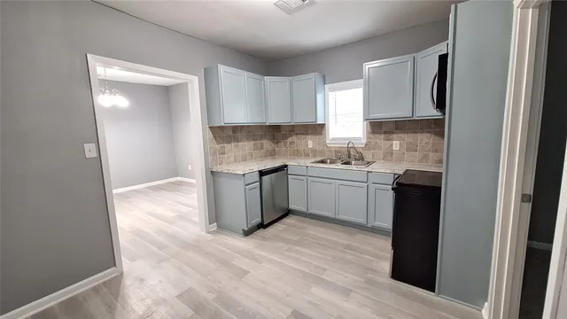 a kitchen with a sink cabinets stainless steel appliances and a window