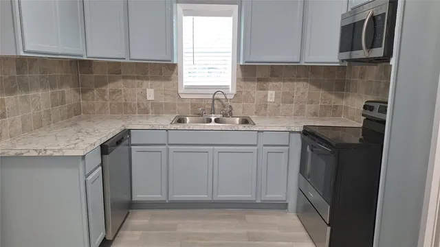 a kitchen with a sink stove and cabinets