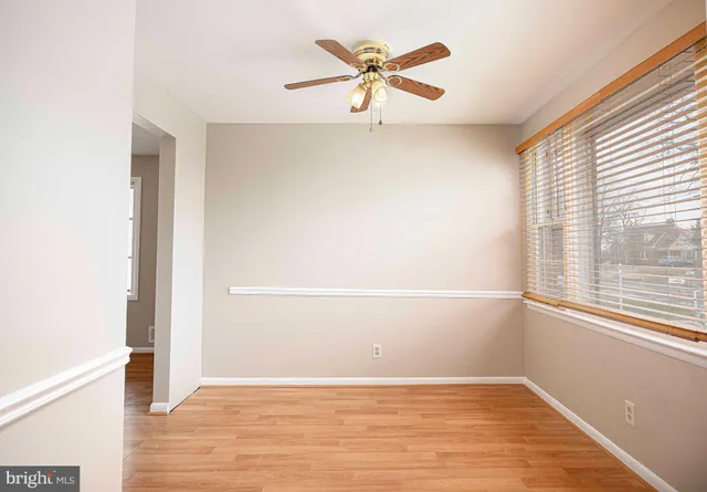 an empty room with a windows and ceiling fan