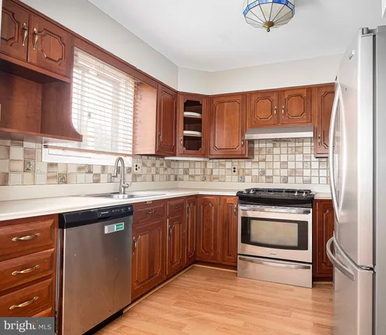 a kitchen with stainless steel appliances granite countertop a sink stove and cabinets