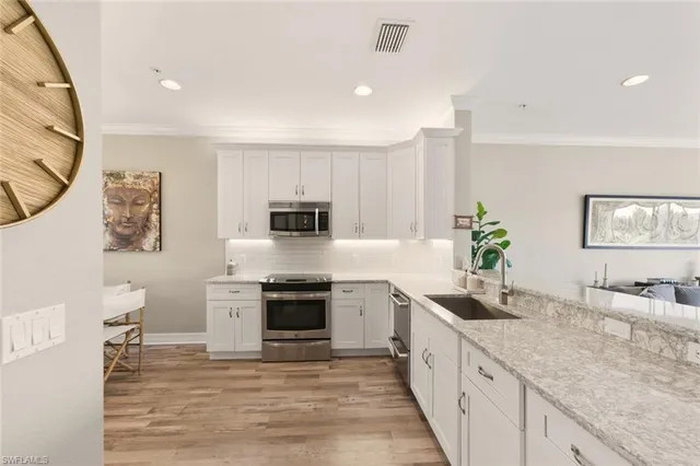 a dining room with kitchen island granite countertop furniture a chandelier a mirror and a potted plant