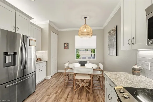 a large kitchen with stainless steel appliances granite countertop a stove a sink and a white refrigerator