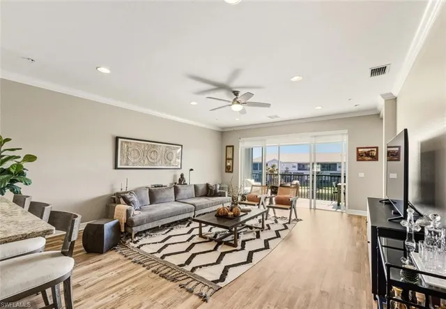 a living room with furniture and a flat screen tv with wooden floor