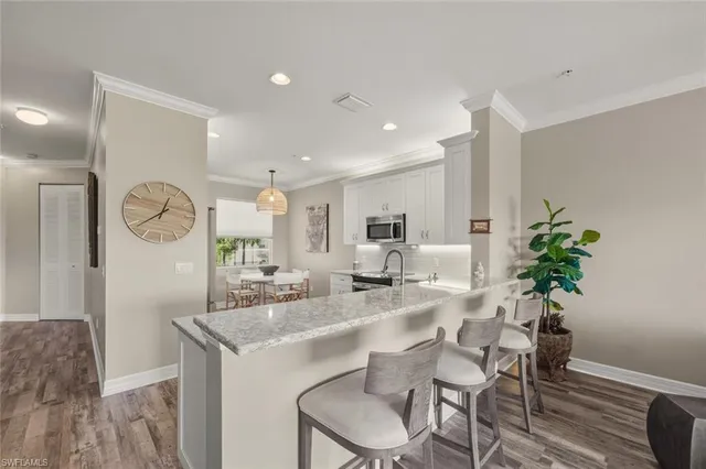 a living room with furniture a rug and kitchen view