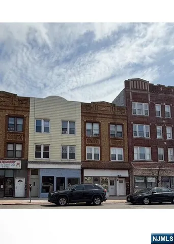 a front view of a residential apartment building with a yard