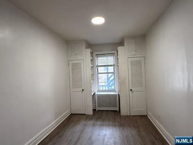 an empty room with a window and wooden floor