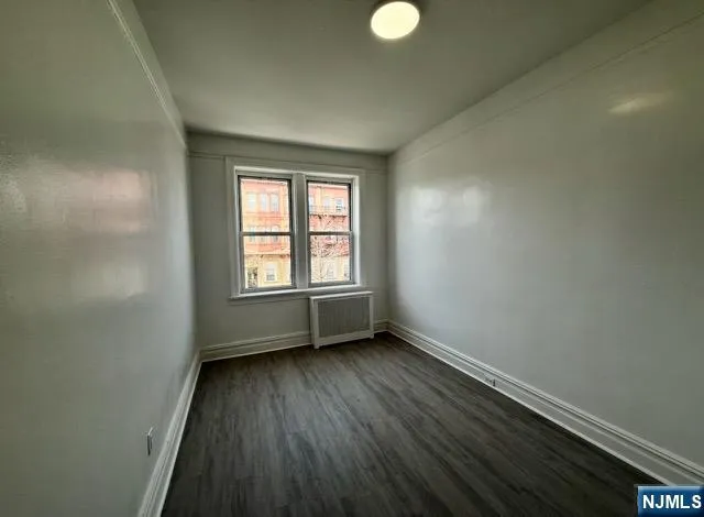 an empty room with a hardwood and a window