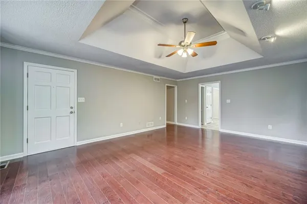 a view of an empty room with window and wooden floor