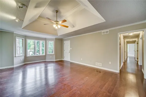 a view of an empty room with window and wooden floor