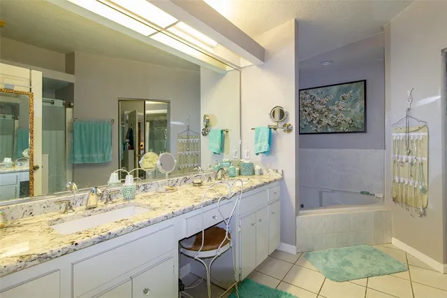 a bathroom with a granite countertop sink mirror and bathtub