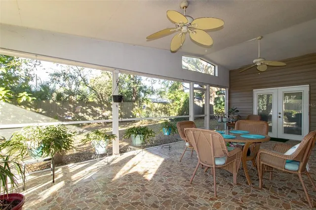 a view of a dining room with furniture a chandelier and large windows