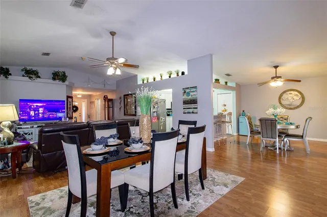 a view of a dining room with furniture a chandelier and wooden floor