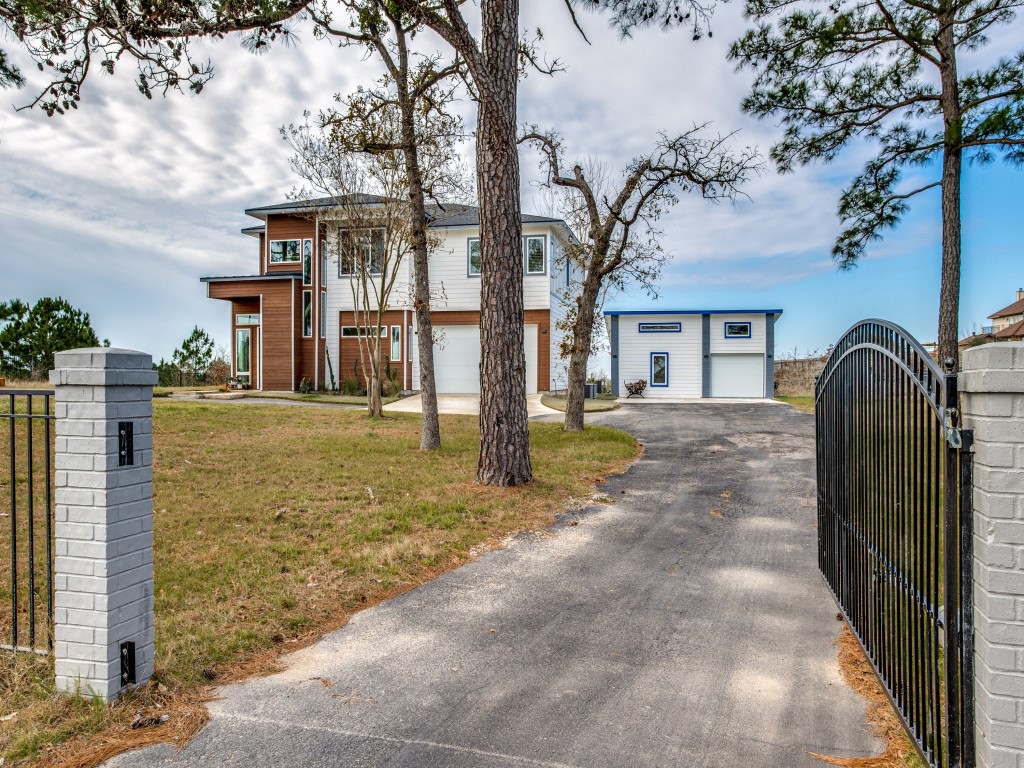 a view of a house with a large tree and wooden fence