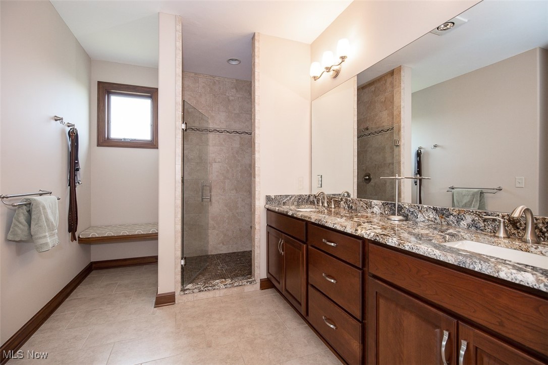 9155 Shank Road Litchfield, OH 44253 - Photo 17 of 47 Full bathroom featuring double vanity, a shower stall, and light tile patterned floors