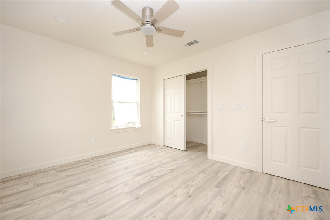 1010 South 4th Street Temple, TX 76504 - Photo 11 of 19 an empty room with wooden floor fan and windows
