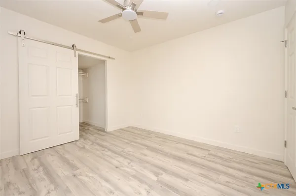 a view of an empty room with wooden floor