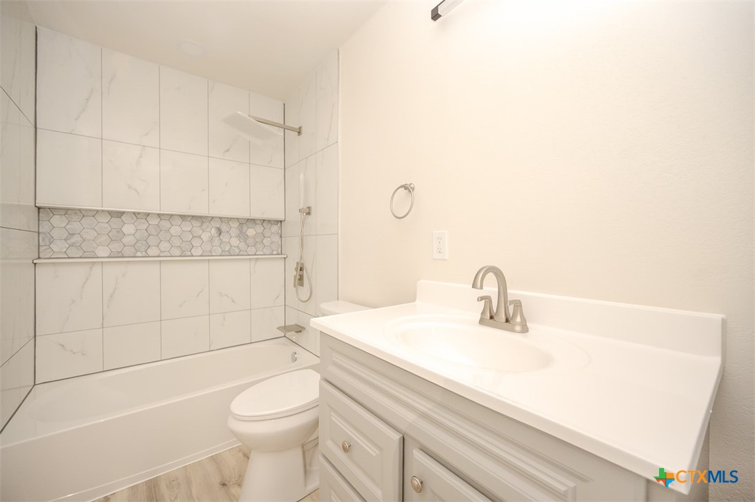 1010 South 4th Street Temple, TX 76504 - Photo 13 of 19 a bathroom with a sink a toilet and shower