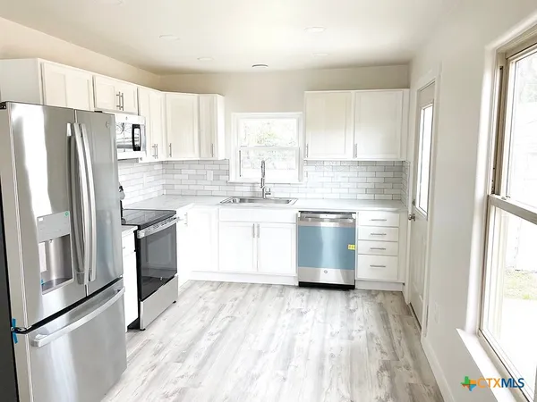 a kitchen with a refrigerator and a sink