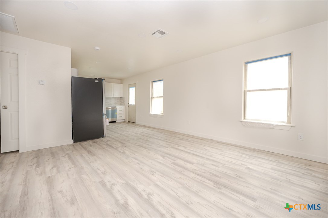 1010 South 4th Street Temple, TX 76504 - Photo 9 of 19 a view of an empty room with wooden floor and a window