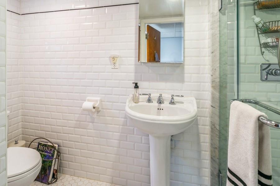 8917 Ridge Boulevard Brooklyn, NY 11209 - Photo 18 of 24 a bathroom with a sink a toilet and mirror