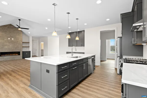 a kitchen with stainless steel appliances granite countertop a sink a stove and a refrigerator