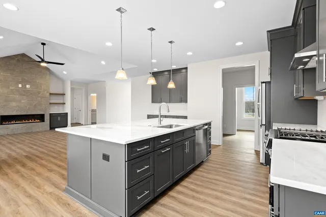 a kitchen with stainless steel appliances granite countertop a sink a stove and a refrigerator