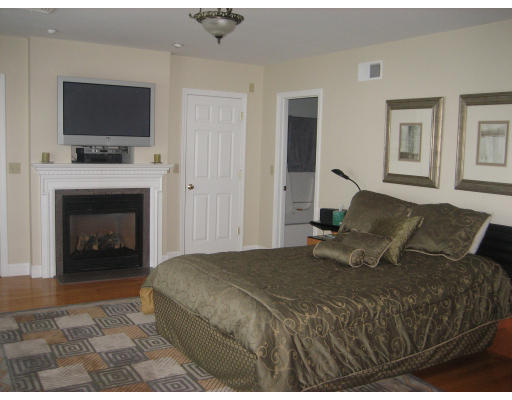 60 Tanglewood Road, Unit 60 Newton, MA 02459 - Photo 8 of 11 a bedroom with a bed and a fireplace