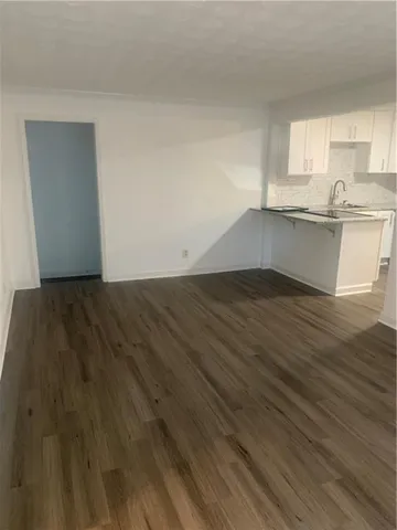 a view of a kitchen with wooden floor and a sink
