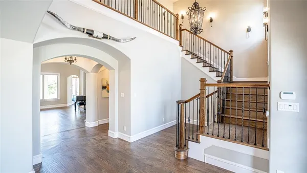 a view of staircase with railing and a chandelier
