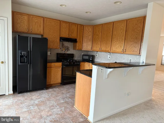 a kitchen with a refrigerator sink and cabinets
