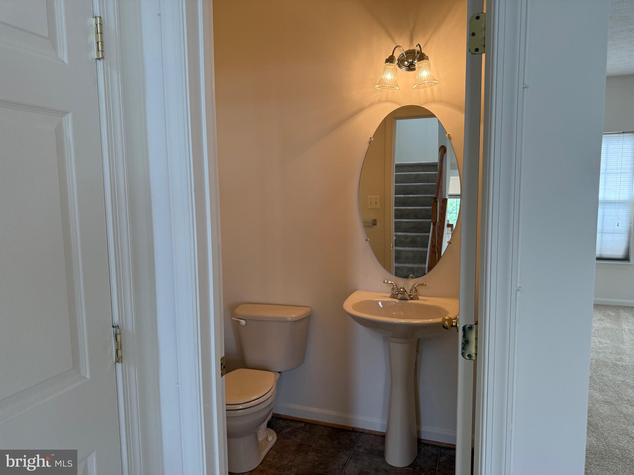 11039 Mill Centre Drive, Unit 11039 Owings Mills, MD 21117 - Photo 21 of 33 a bathroom with a toilet and a mirror
