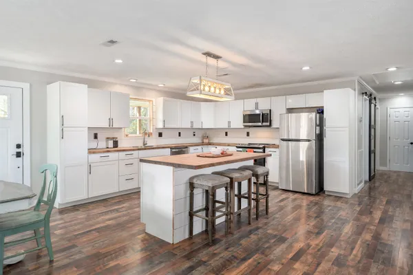 a kitchen with a refrigerator and a stove top oven