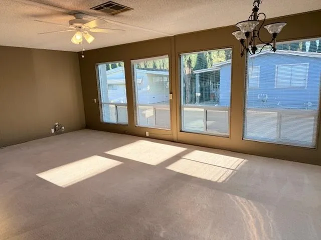 a view of a livingroom with a ceiling fan and window